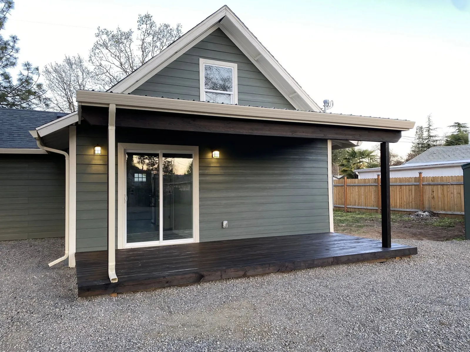 Home with sage-green lap siding, cream trim, and a covered porch in the Ashland, Oregon area served by Next Gen Contracting
