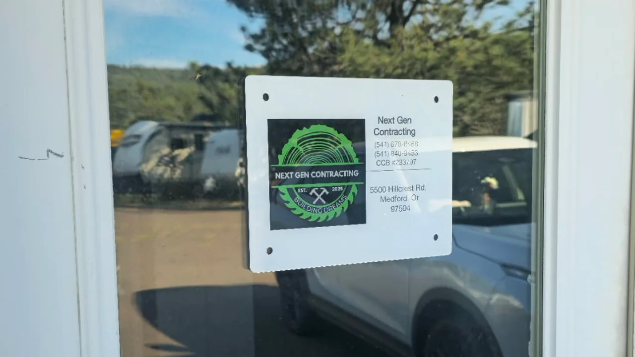 Next Gen Contracting office sign on the glass door of their Medford, Oregon location, showing the logo and CCB #233797