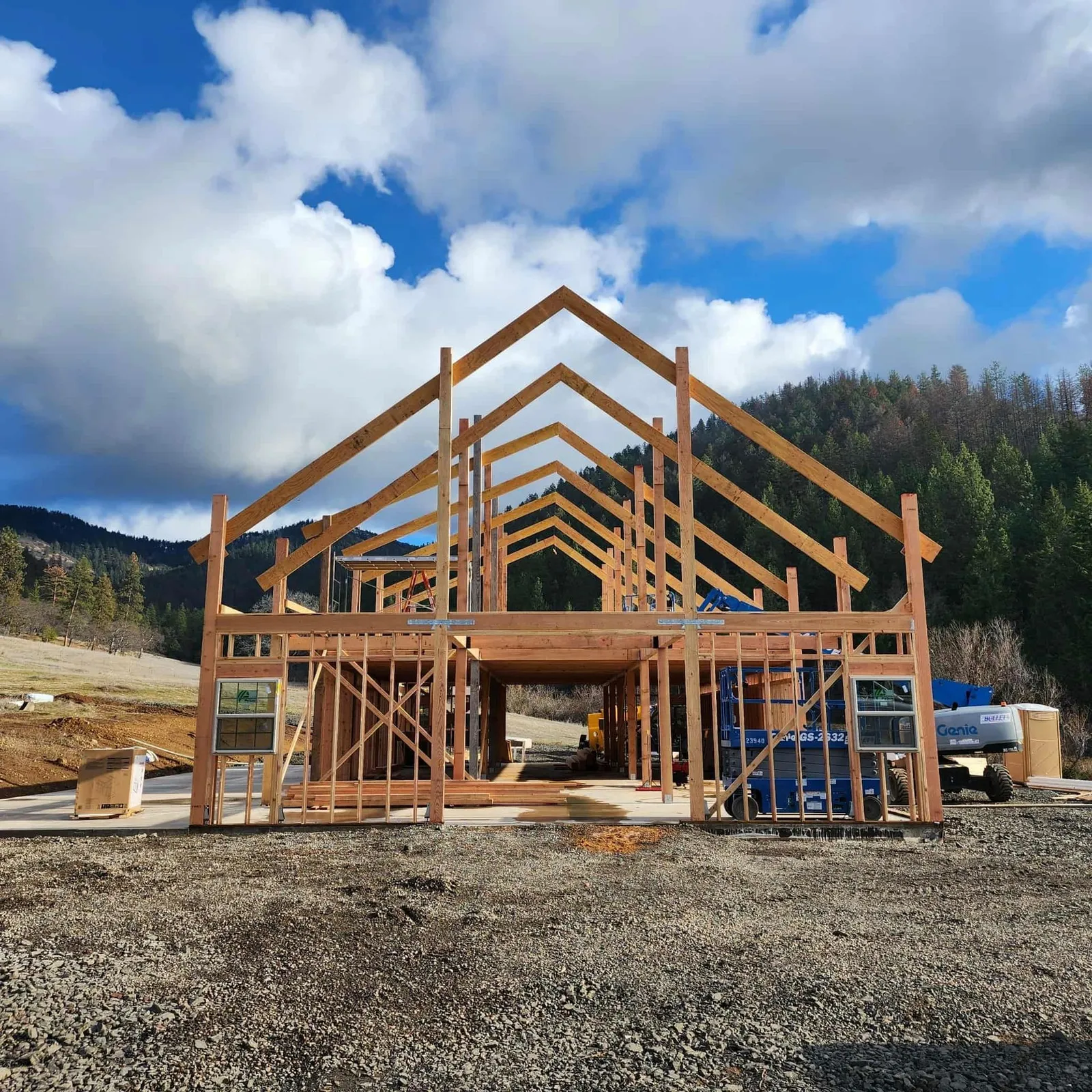 Home addition under construction with exposed timber framing on a forested Southern Oregon hillside, Next Gen Contracting
