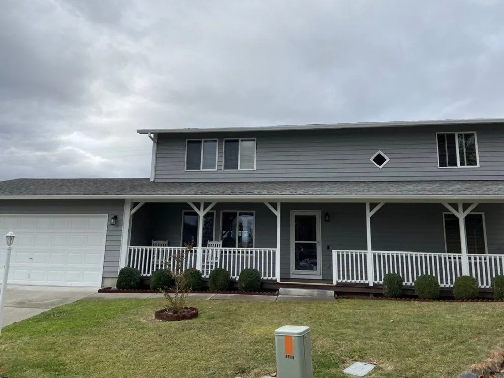 Two-story home with gray lap siding and clean white trim, exterior painting by Next Gen Contracting in Southern Oregon